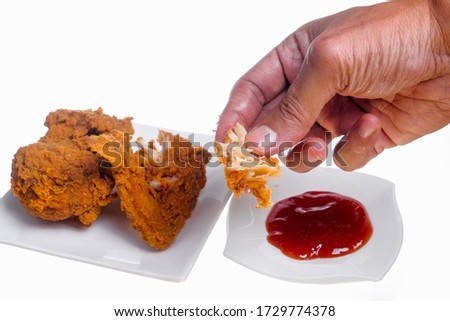 Hand holding fried chicken on white background
