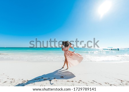 Woman enjoying sunny day on the tropical caribbean sandy beach landscape with turquoise sea and blue sky 