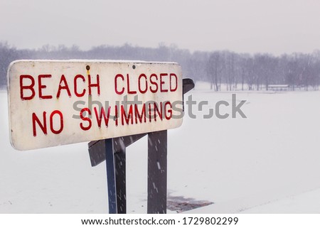 Closed sign and now swimming sign during snowy winter in northeast Ohio