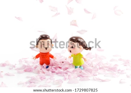 Two dolls among the petals of the cherry blossom