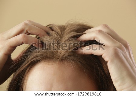 Close up view at woman applaying natural dry shampoo on hair roots. Brunette uses organic non-toxic chemicals free dry shampoo. Concept of healthy, low toxic, zero waste living. Royalty-Free Stock Photo #1729819810