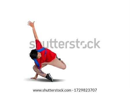 Picture of teenager student doing handstand in studio while carrying backpack, isolated on white background 