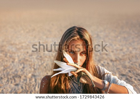 beautiful young stylish woman close up portrait with orchid flower at sunset
