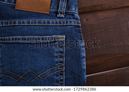 Close up of denim jeans on the background of old wooden boards, label mockup.