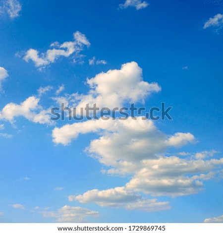 Light cumulus clouds on blue sky .