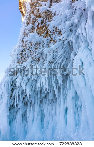 Beautiful shape Frozen icicle resulted from rapid freezing of the waves that hit the cliff in a blur view of cliff from behind of the Baikal Lake, Siberia, Russia