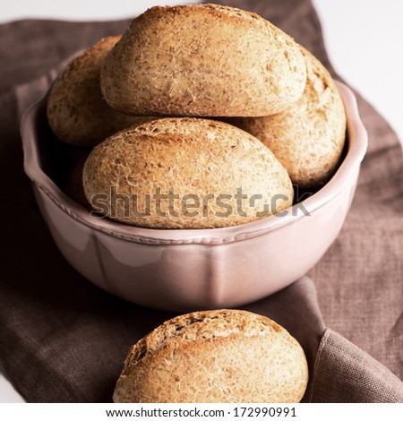 Bread buns in bowl on table cloth