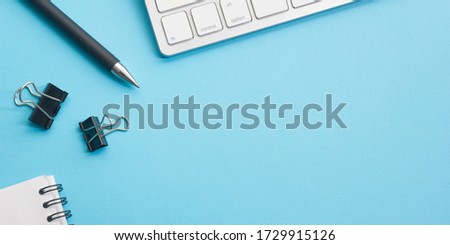 Blue desk office with laptop, smartphone and other work supplies with cup of coffee. Top view with copy space for input the text. Designer workspace on desk table essential elements on flat lay