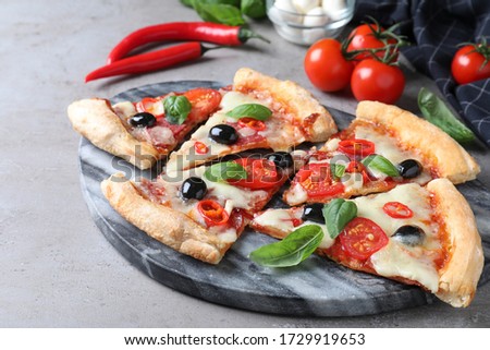 Pieces of delicious pizza Diablo on grey table