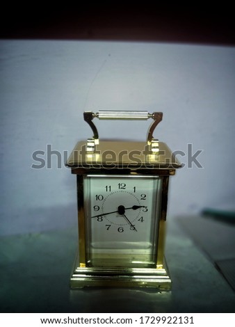 Bokeh shot of a small table watch with selective focus. Golden watch is kept for sale inside a shop with copy space.