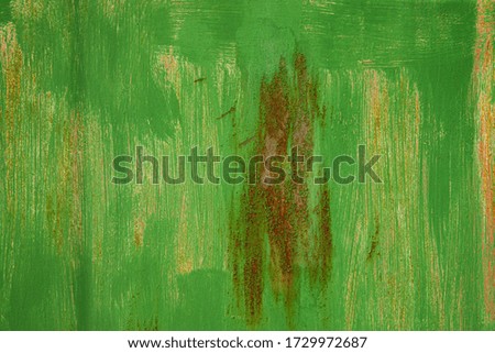 Old painted textured peeling green background with rust stain.