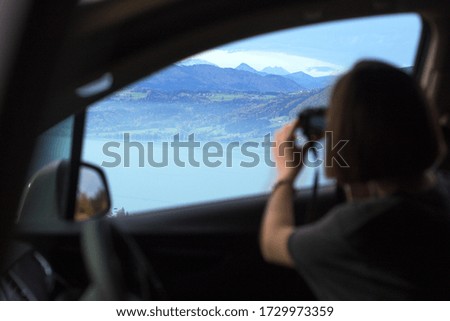 girl travels and takes pictures on camera from a car window
