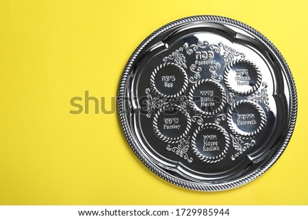 Passover Seder plate (keara) on yellow background, top view with space for text. Pesah celebration