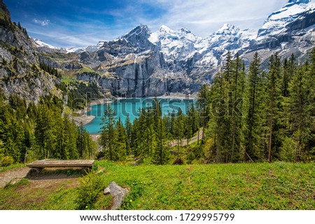Amazing tourquise Oeschinnensee with waterfalls, wooden chalet and Swiss Alps, Berner Oberland, Switzerland. Royalty-Free Stock Photo #1729995799