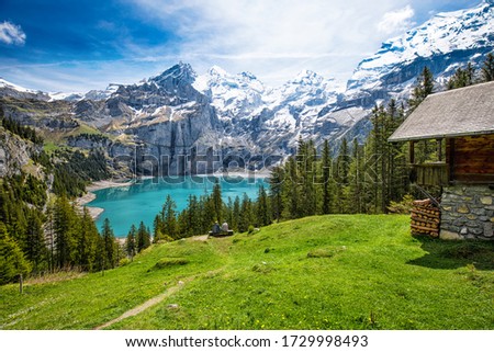 Amazing tourquise Oeschinnensee with waterfalls, wooden chalet and Swiss Alps, Berner Oberland, Switzerland. Royalty-Free Stock Photo #1729998493