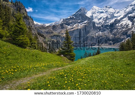 Amazing tourquise Oeschinnensee with waterfalls, wooden chalet and Swiss Alps, Berner Oberland, Switzerland. Royalty-Free Stock Photo #1730020810