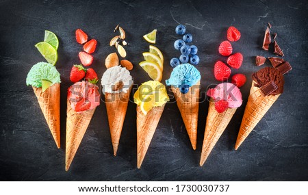 Asorted of ice cream scoops with cones in row on black background. Colorful set of ice cream scoops of different flavours. Sweet icecream like chocolate, lemon, lime, almond, strawberries, vanilla. Royalty-Free Stock Photo #1730030737