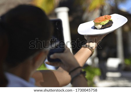 Girl photographs hamburger for a social network pubblication
