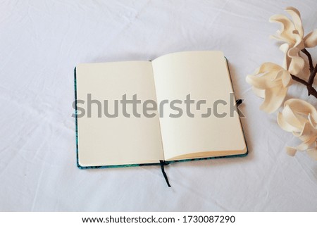 Elegant and minimalist image of tuberose with beige background and field notebook with smooth sheets