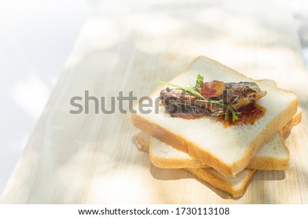 Bread and Mackerel on Wood cutting board with Natural light with copy space for text, Breakfast and worm light.