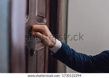 Cropped view of collector knocking on door with hand Royalty-Free Stock Photo #1730122294