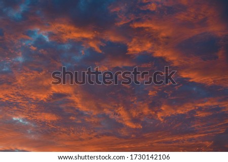 Amazing sunset sky. Bright contrasting colors of the clouds. Orange, gold and blue. Background, wallpaper for stories, phone or print.