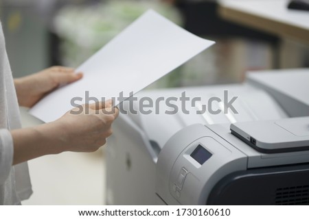 Businesswoman making copies with copy machine Royalty-Free Stock Photo #1730160610