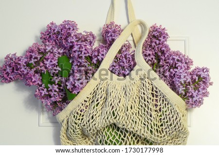 Blooming spring lilac flowers in string bag. Spring background.