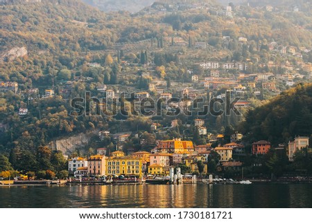 A paranomic view sunrise of colorful house front to lake with background of mountain in Varenna Esino, small beautiful village of famous tourist place lake como, Italy, picture with grain film effect