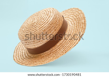 Boater straw hat flying isolated in studio. Concept of fashion clothing accessories and beach holidays Royalty-Free Stock Photo #1730190481