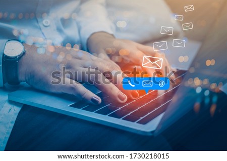 Contact us or Customer support hotline people connect. Businessman using a laptop computer with the (email, call phone, mail) icons. Royalty-Free Stock Photo #1730218015