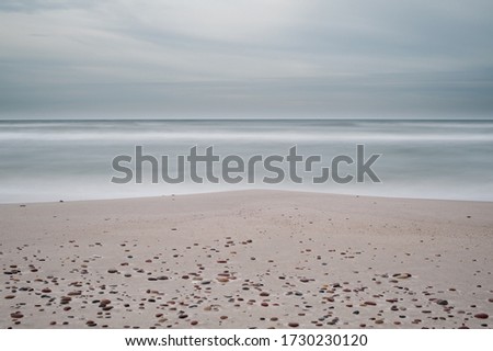 Soft surface of gray sea with sandy beach. Background
