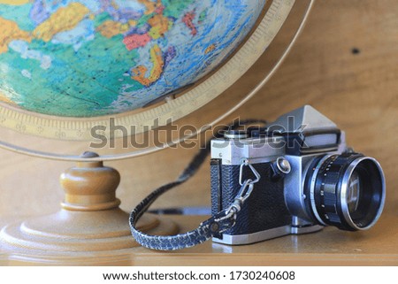 Close-up of antique cameras on a wooden table Globe as background selective focus and shallow depth of field