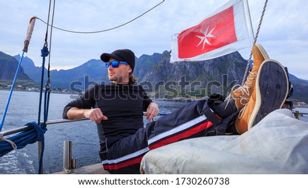 Sailor man resting in boat in open sea in Norway Royalty-Free Stock Photo #1730260738