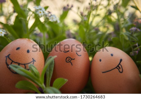 A group of funny hand drawn smiley easter eggs in a blossoming garden background