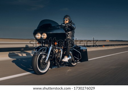 Motorcycle driver riding alone on asphalt motorway. Biker drive fast the highway Royalty-Free Stock Photo #1730276029