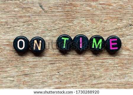 Black bead with color letter in word on time on wood background