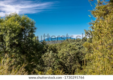
The Volcano and the Nevado de Colima in the distance, seen from the Mazamitla forest. Landscape view.  Royalty-Free Stock Photo #1730295766