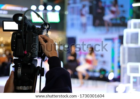 professional video production camera recording live event on stage. television social media broadcasting seminar conference. Royalty-Free Stock Photo #1730301604