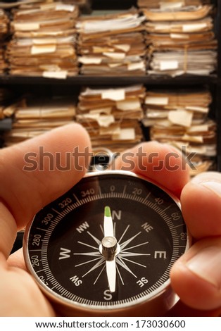 Hand with compass on paper documents