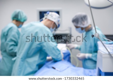 Blurred view of doctors operating patient in surgery room