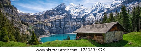 Amazing tourquise Oeschinnensee with waterfalls, wooden chalet and Swiss Alps, Berner Oberland, Switzerland. Royalty-Free Stock Photo #1730334676
