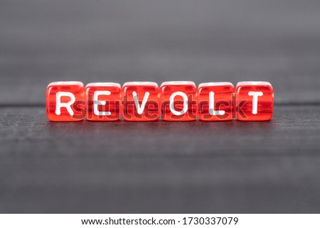 Revolt word from red cubes on black background. Revolution, protest concept