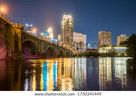 The night lights of the Minneapolis skyline reflect in the Mississippi River.