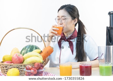 A cute girl makes vegetable juice, with carrot apple orange cranberry beetroot and mango in chef suit. Healthcare concept.
