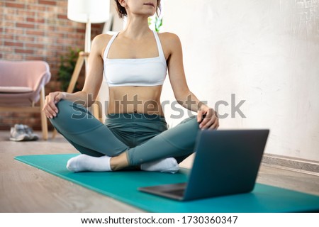 oung sporty slim woman has internet video online fitness training instructor modern laptop screen. Healthy lifestyle concept, online fitness and sport lessons. Stretching online. Royalty-Free Stock Photo #1730360347