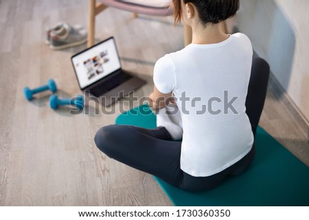 oung sporty slim woman has internet video online fitness training instructor modern laptop screen. Healthy lifestyle concept, online fitness and sport lessons. Stretching online. Royalty-Free Stock Photo #1730360350