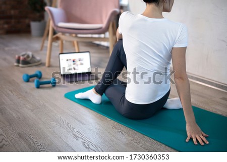 oung sporty slim woman has internet video online fitness training instructor modern laptop screen. Healthy lifestyle concept, online fitness and sport lessons. Stretching online. Royalty-Free Stock Photo #1730360353