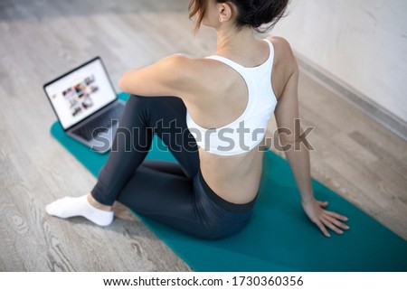 oung sporty slim woman has internet video online fitness training instructor modern laptop screen. Healthy lifestyle concept, online fitness and sport lessons. Stretching online. Royalty-Free Stock Photo #1730360356