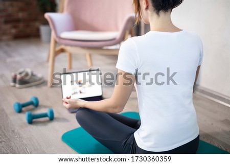 oung sporty slim woman has internet video online fitness training instructor modern laptop screen. Healthy lifestyle concept, online fitness and sport lessons. Stretching online. Royalty-Free Stock Photo #1730360359